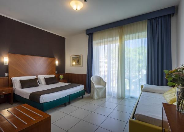 Modern room with double bed and balcony.